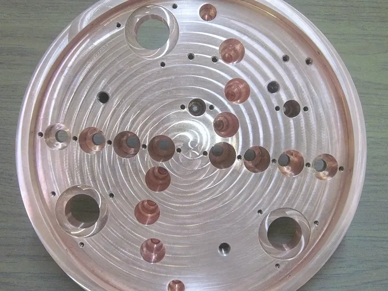 Circular aluminum platen with a spiral-machined face and copper-alloy inserts
