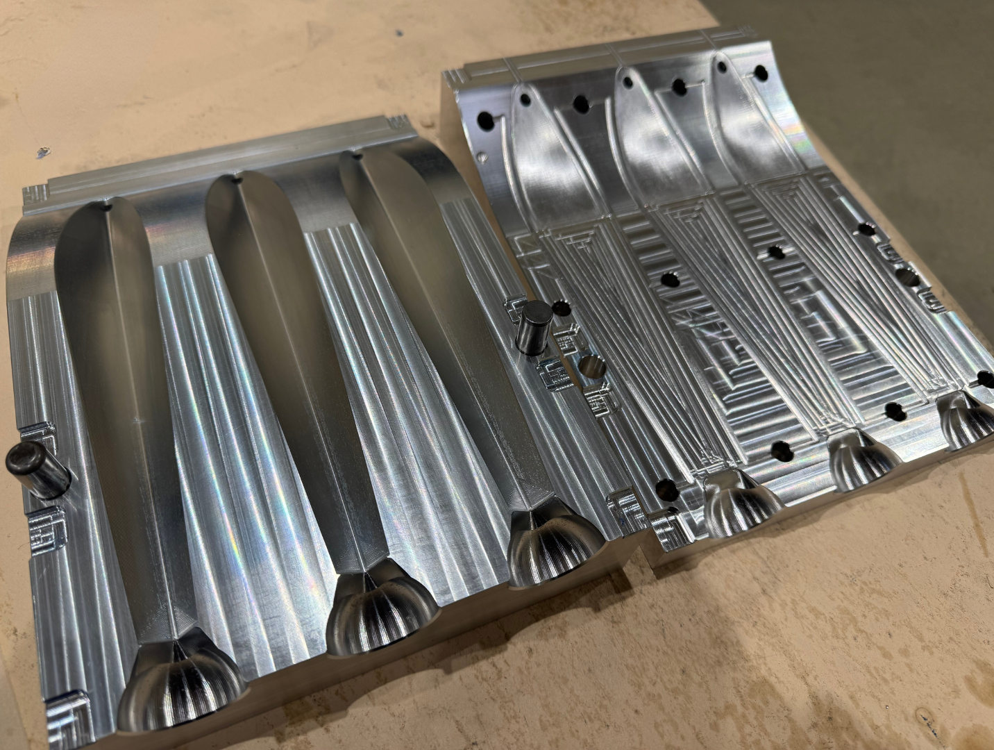 Two CNC-machined aluminium mould halves for kayak paddle blades, fresh off the machine.