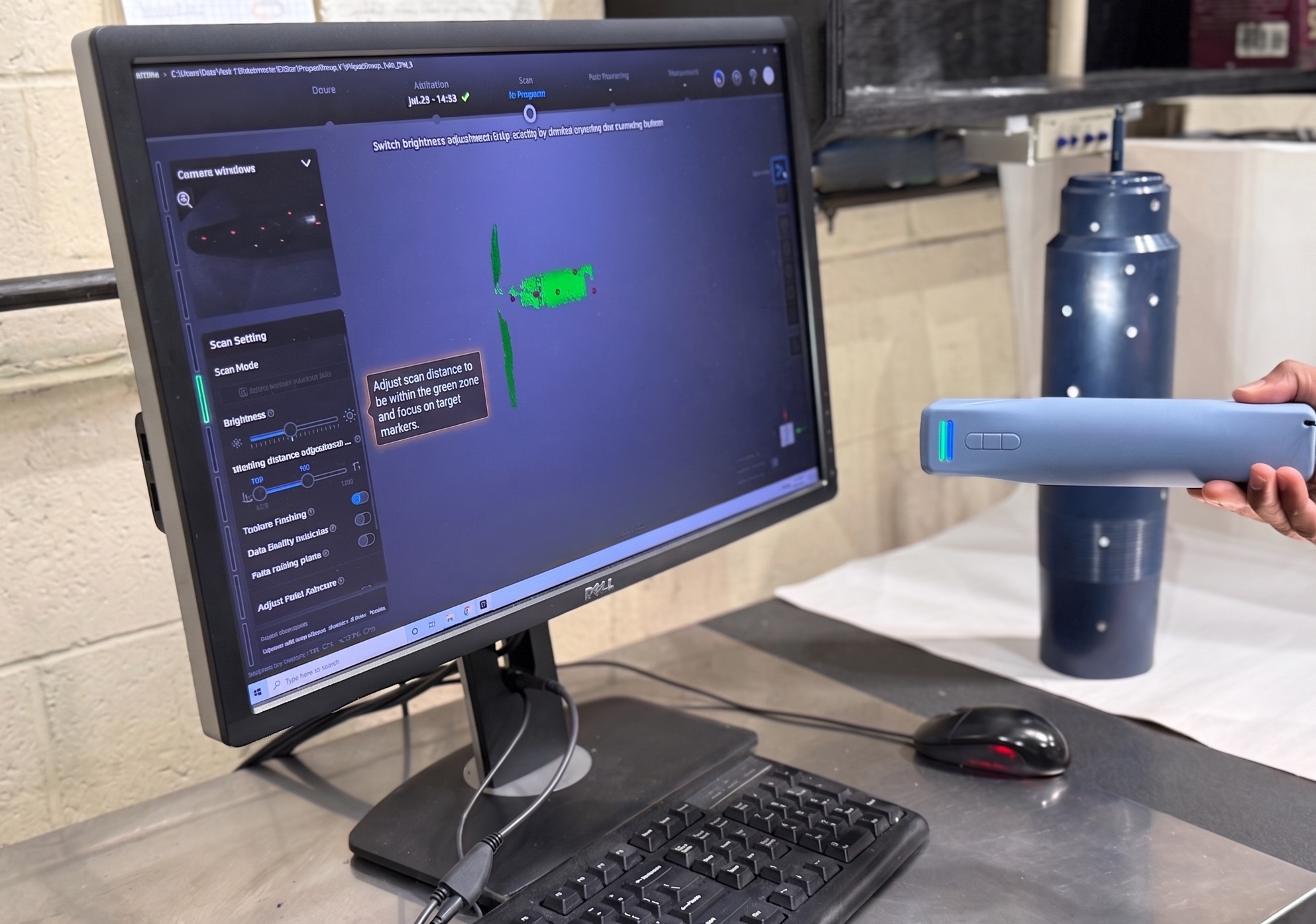 A technician 3D-scanning a red fuel can with a handheld scanner to capture its geometry.