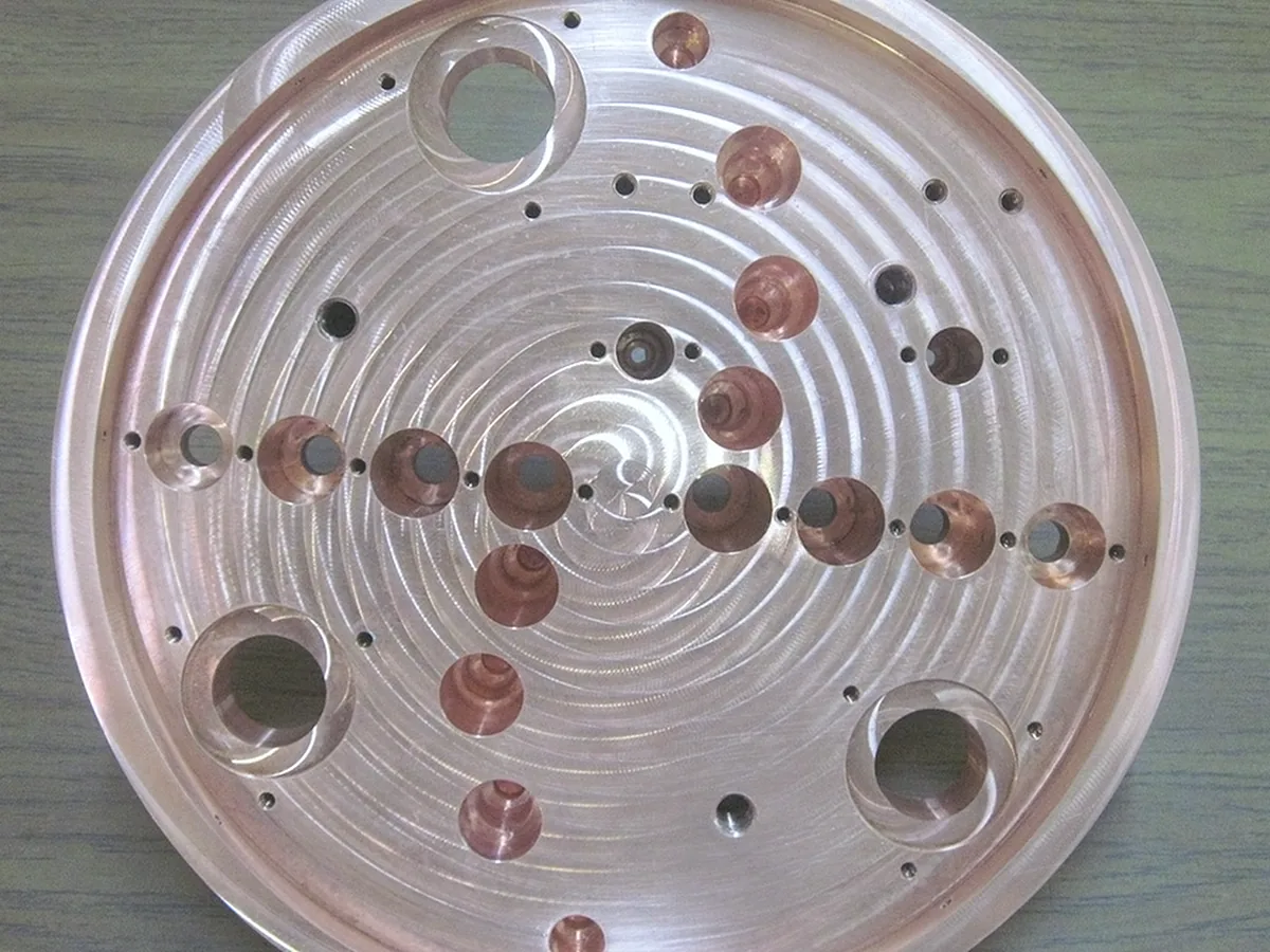 Circular aluminum platen with a spiral-machined face and copper-alloy inserts