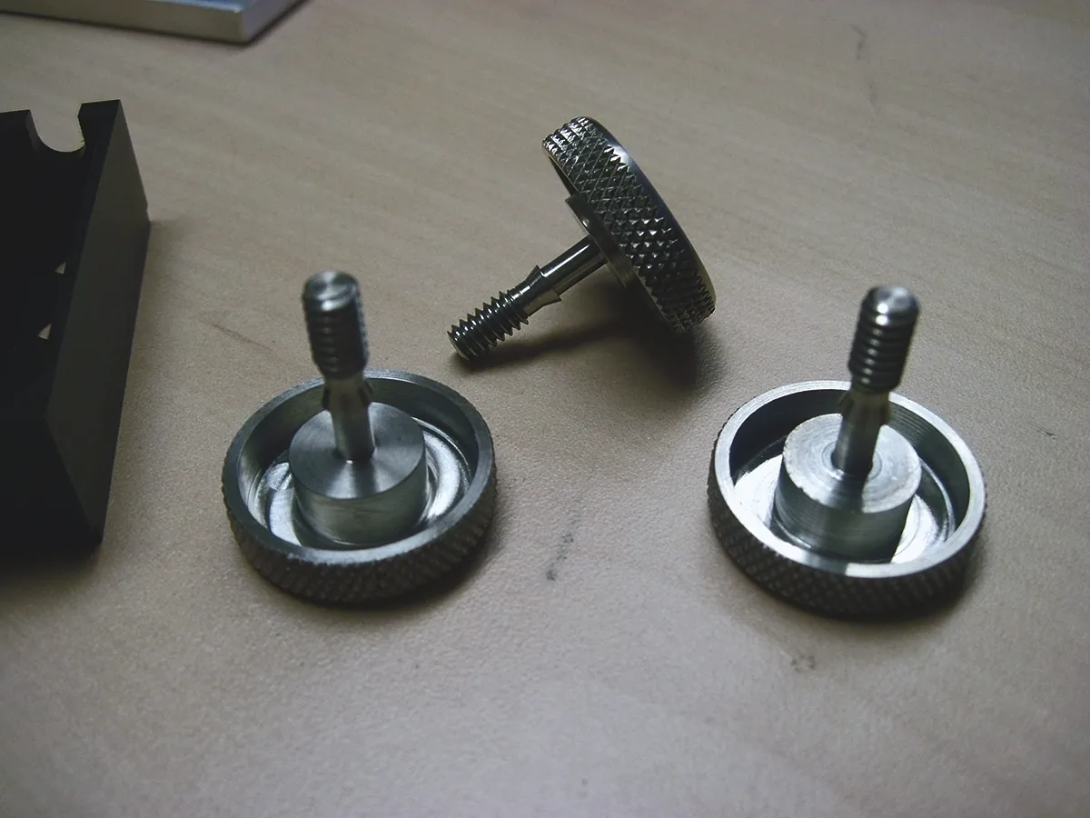 Three knurled thumbscrews with shouldered threaded studs