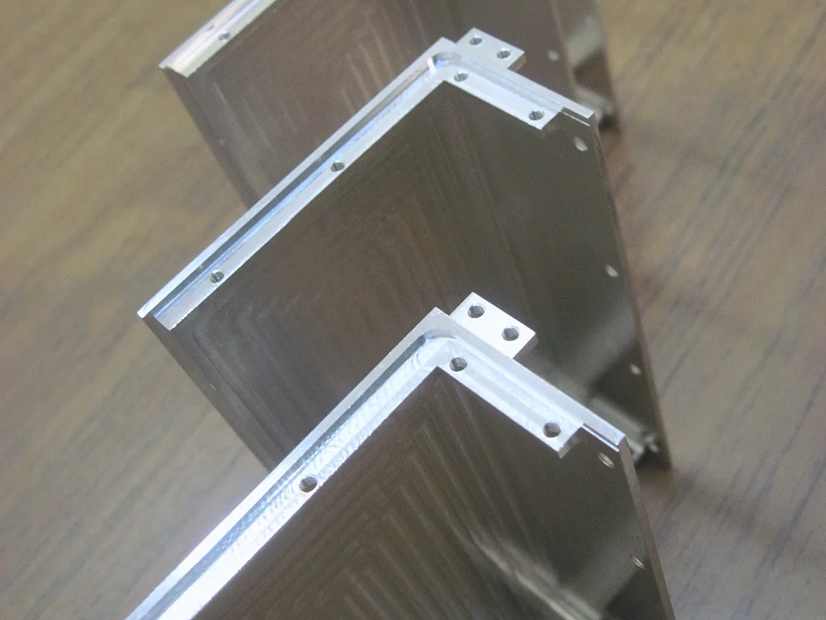 Row of L-shaped aluminum brackets with drilled mounting holes
