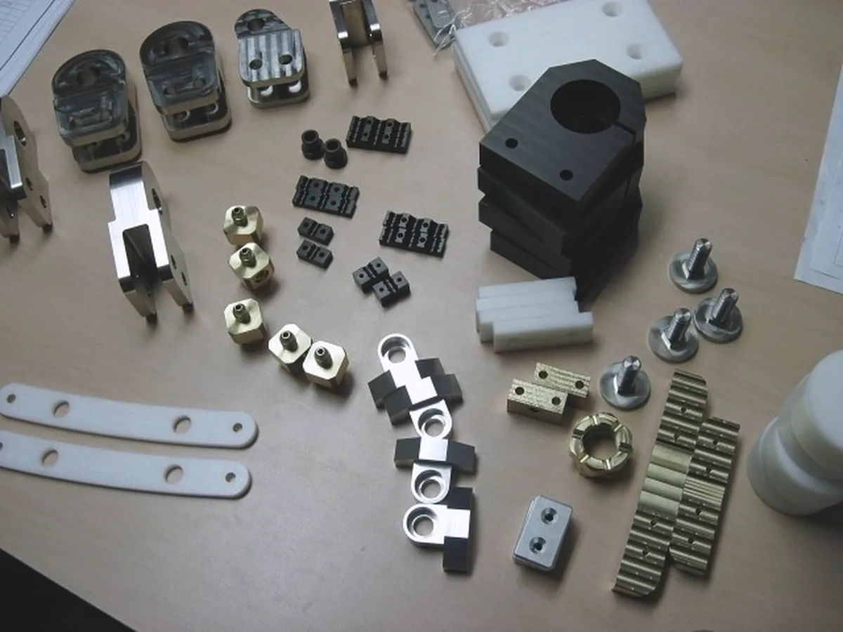 Assortment of small machined parts in plastic, brass and steel