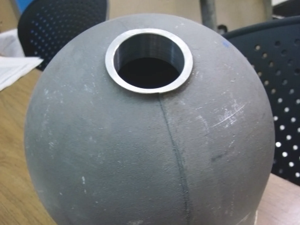 Grey sphere with a machined bore and an aluminum ring insert