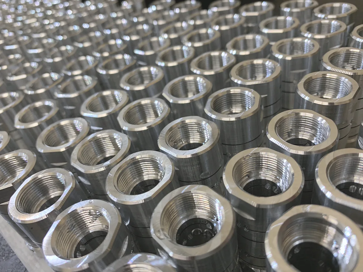 Rows of threaded hex-flange fittings from a production run