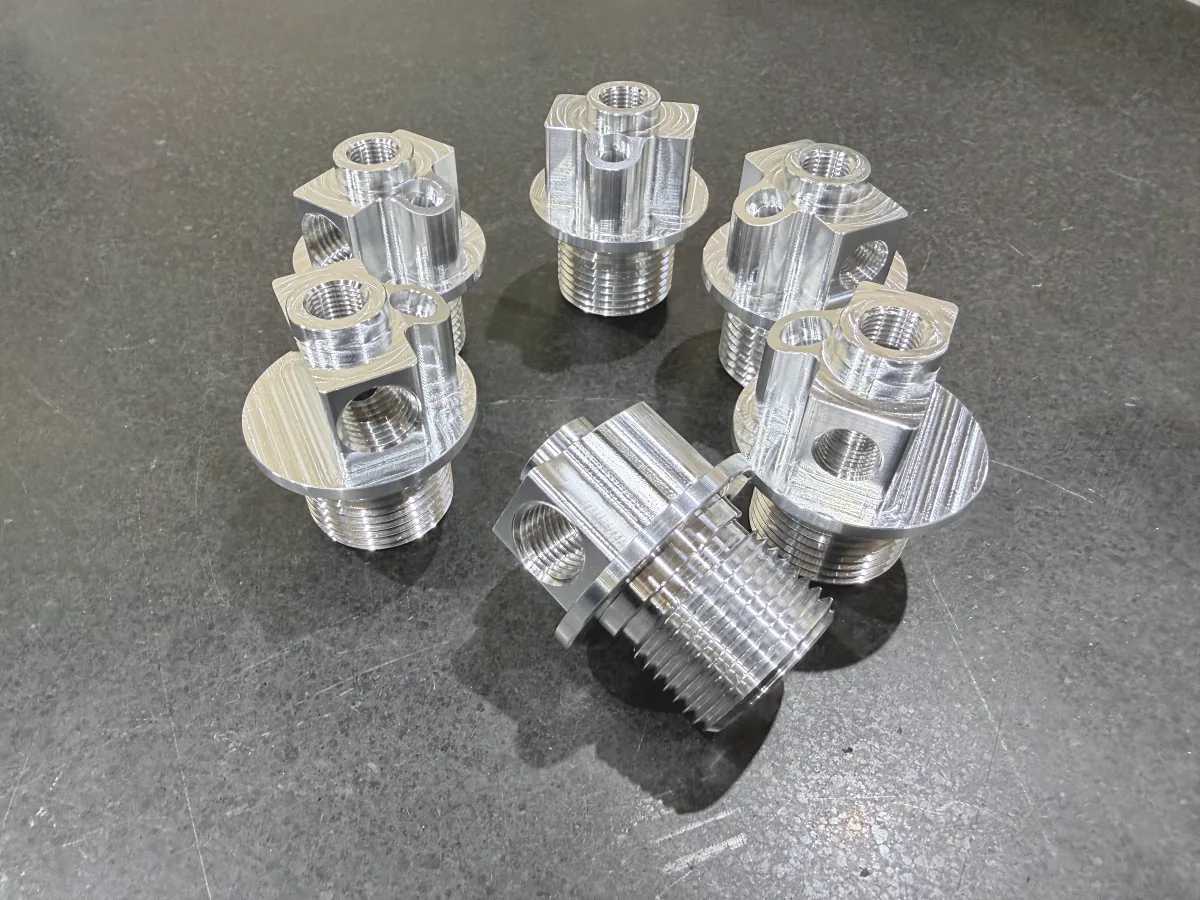 Aluminum fittings with threaded ports and flanged bases