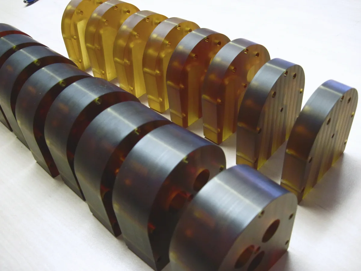 Rows of amber polymer and steel discs with machined pockets